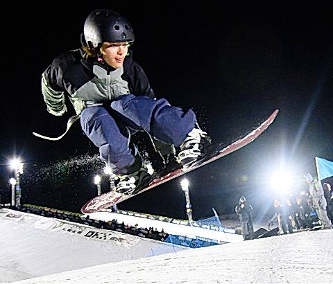 snowboarder doing a melon grab over a ramp